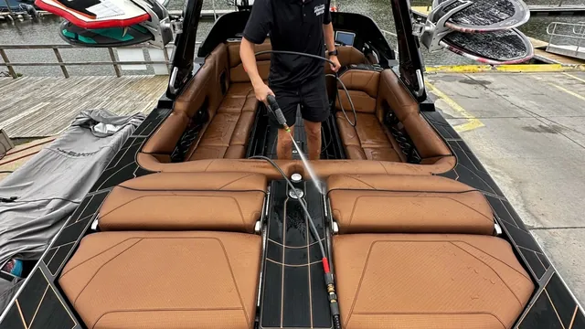 Rinsing the deck of a Centurion wake boat during a marine detail